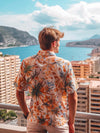 Homme vêtu d'une chemise hawaïenne qui regarde au loin depuis le balcon d'un immeuble à Monaco